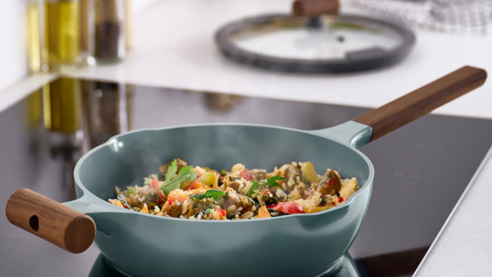 Turquoise pan with wood handles, on induction stovetop