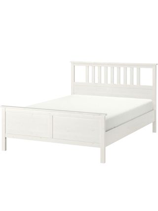 White wooden bed with headboard and solid footboard with white mattress on it