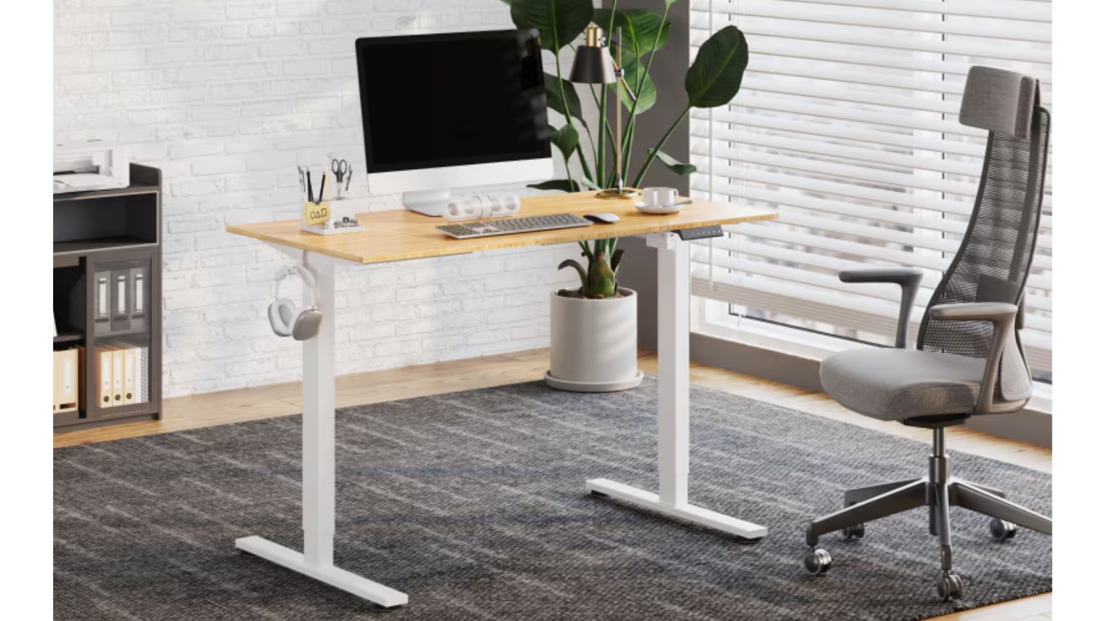 FlexiSpot E2 in a home office with a monitor on top and a chair to the side