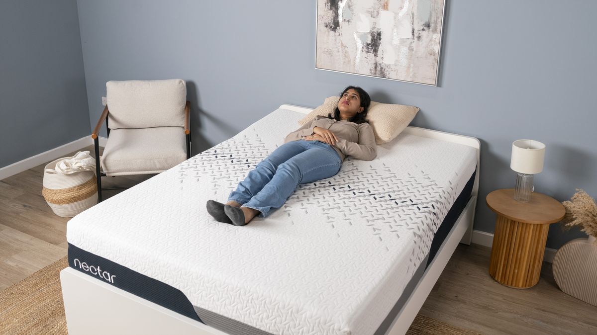 A tester for Toms Guide lying on their back on the Nectar Luxe mattress