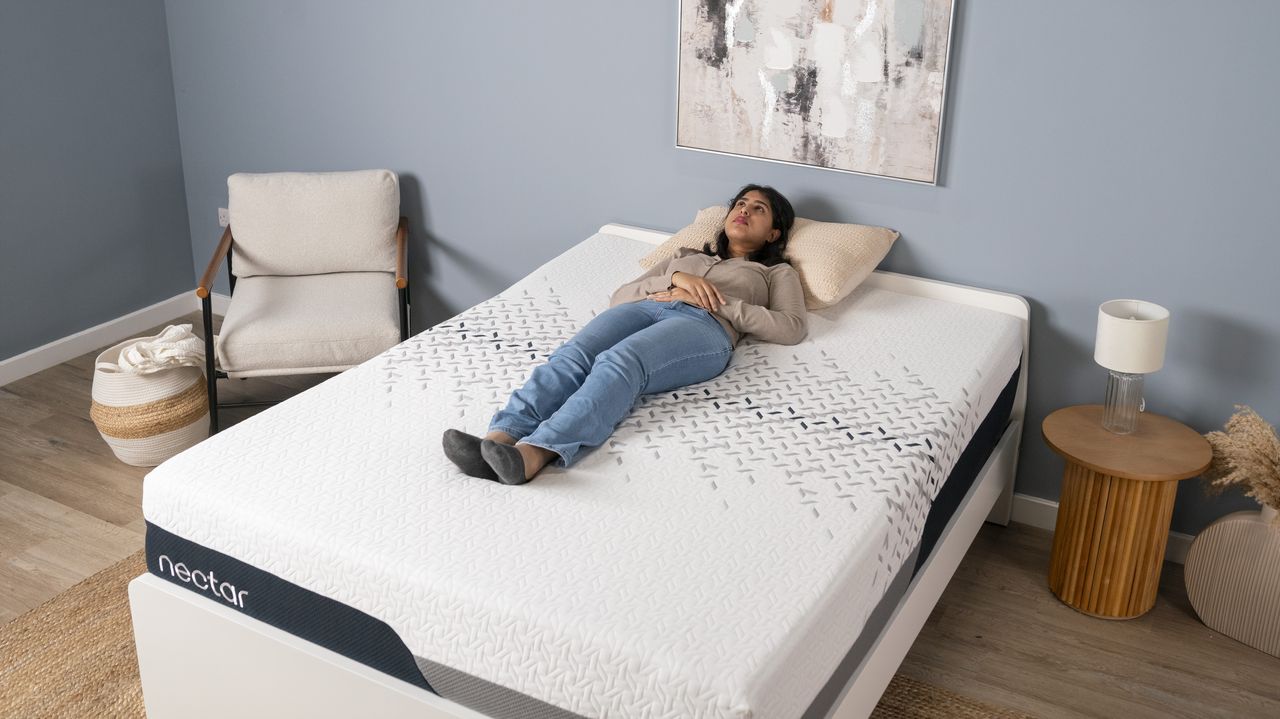 A tester for Toms Guide lying on their back on the Nectar Luxe mattress