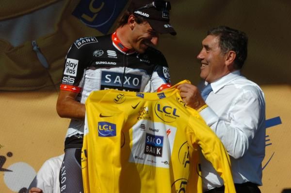 Fabian Cancellara (Saxo Bank) collects the yellow jersey from Eddy Merckx