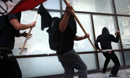 Anarchists smash the windows of a bank during an Occupy-related demonstration in Oakland
