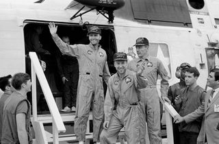 The crewmembers of the Apollo 13 mission, step aboard the USS Iwo Jima recovery ship after successfully surviving their journey around the moon and splashing down in the Pacific ocean. 