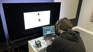 TechRadar reviewer measuring TV accuracy with test equipment
