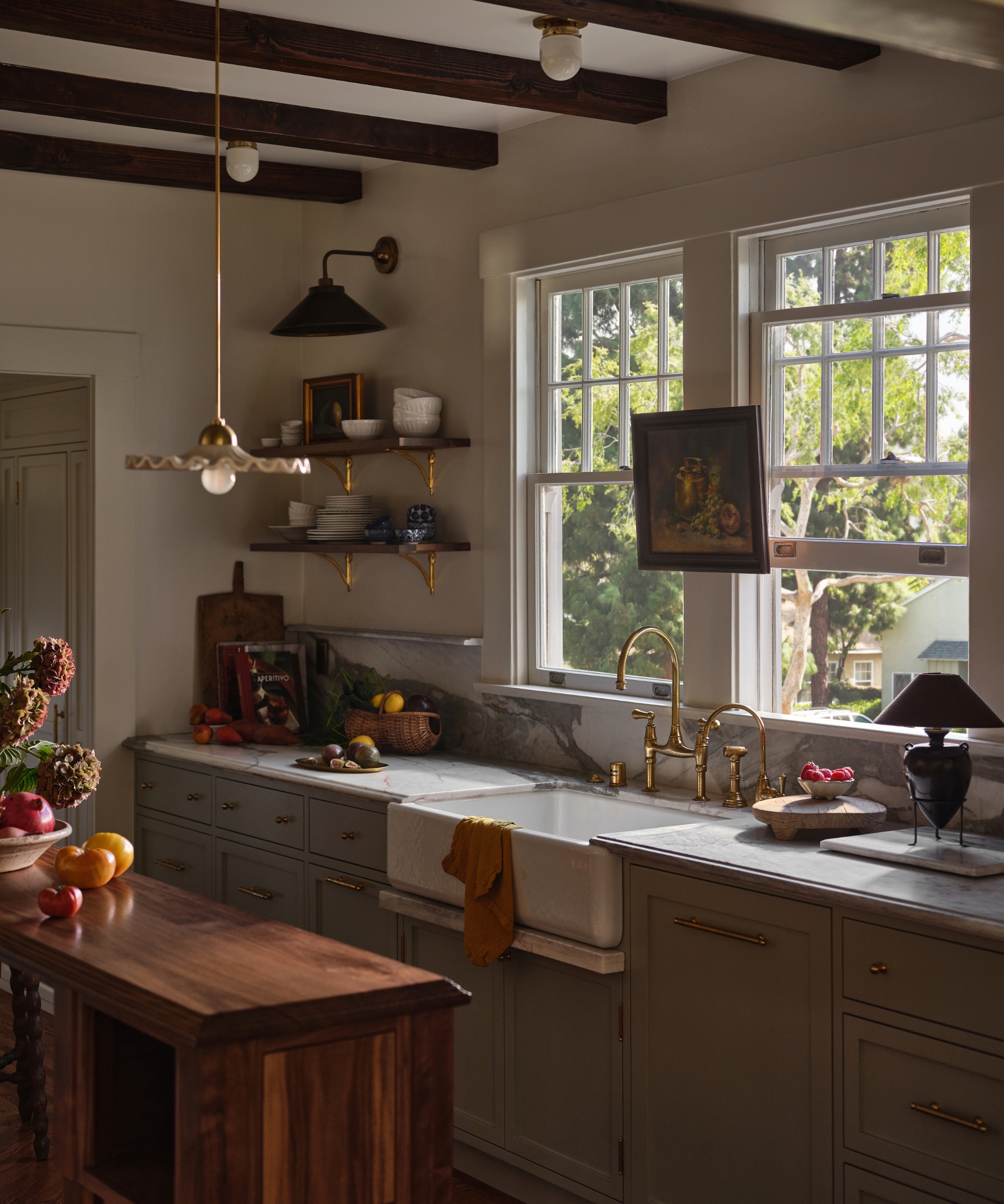 A fall kitchen with open shelved filled with collected dinnerware and cutting boards