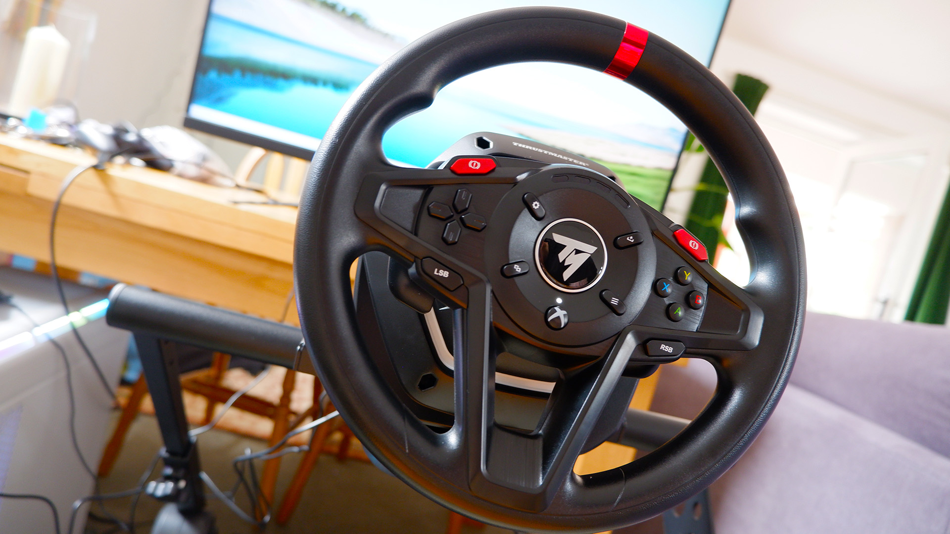 The Thrustmaster T128 racing wheel mounted on a Monoprice stand.