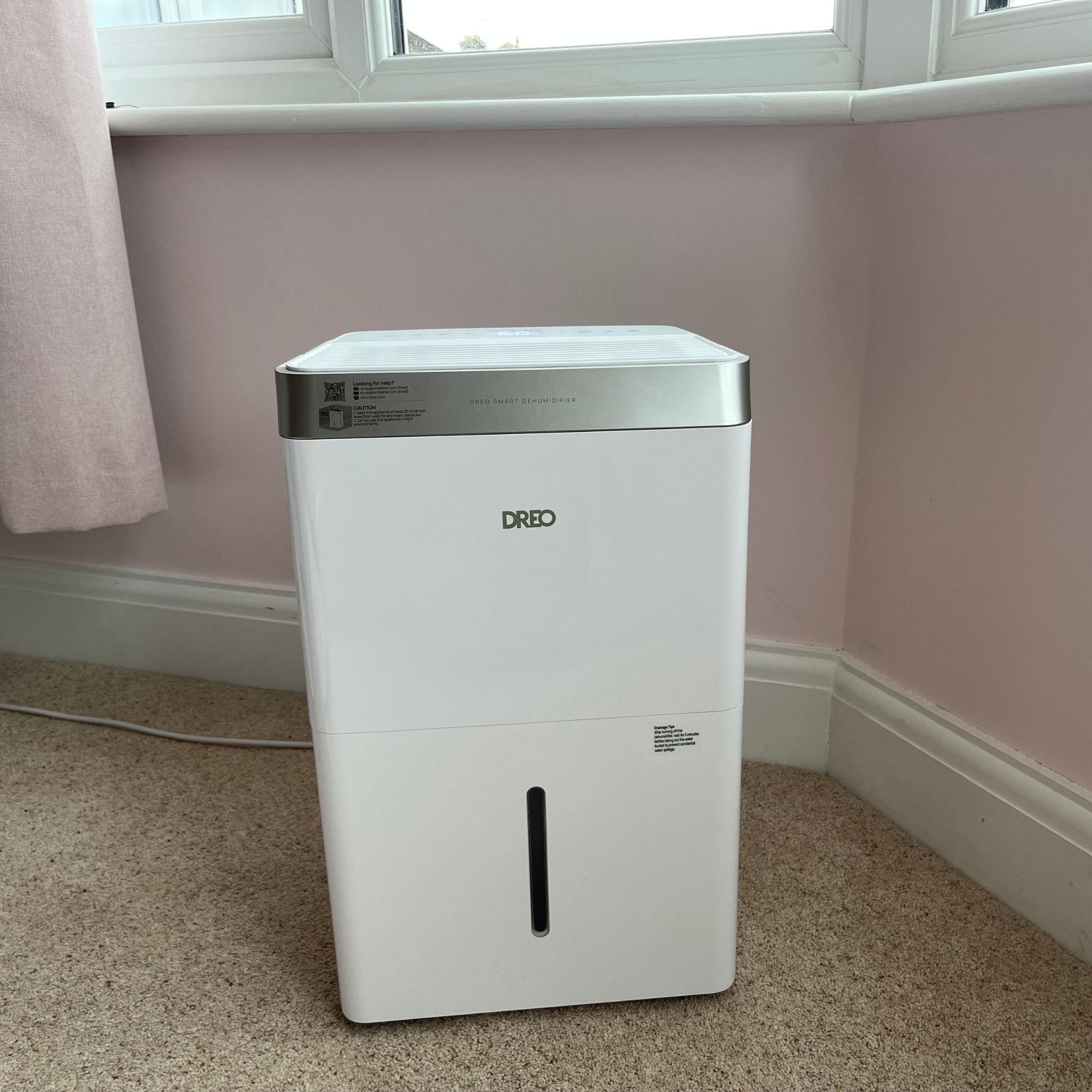 DREO dehumidifier in bedroom next to bay window