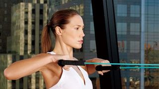 woman working out in front of window with view of city