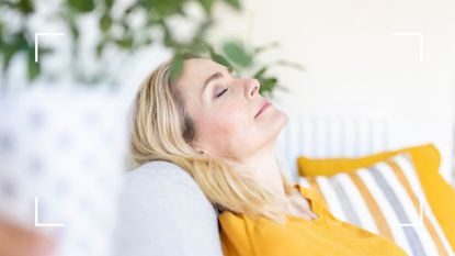 Woman leaning back on the sofa, listening to one of the best mindfulness apps