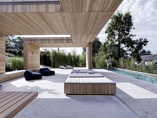 The second veranda is at the level of the open pool house and decorated with similarly low, simple seating
