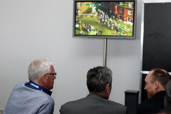 Wouter Vandenhoutte, Eddy Merckx and Patrick Lefevere watch the action on television