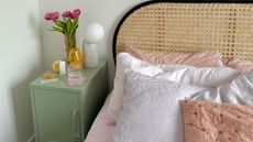 Green nightstand next to white bed