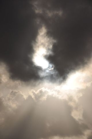 Solar Eclipse Seen Through Clouds Over Palm Cove, Australia