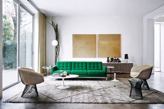 modern living room with green knoll sofa, gray rug, two armchairs, a side table, a tulip coffee table, two pieces of artwork and a floor lamp in the corner