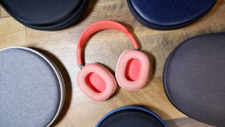 AirPods Max headphones in pink surround by cases