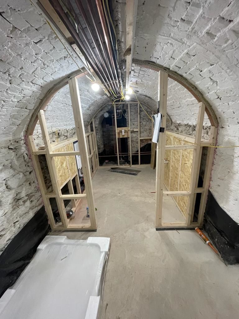 The air raid shelter bathroom being constructed with stud wall added in the curved hallway