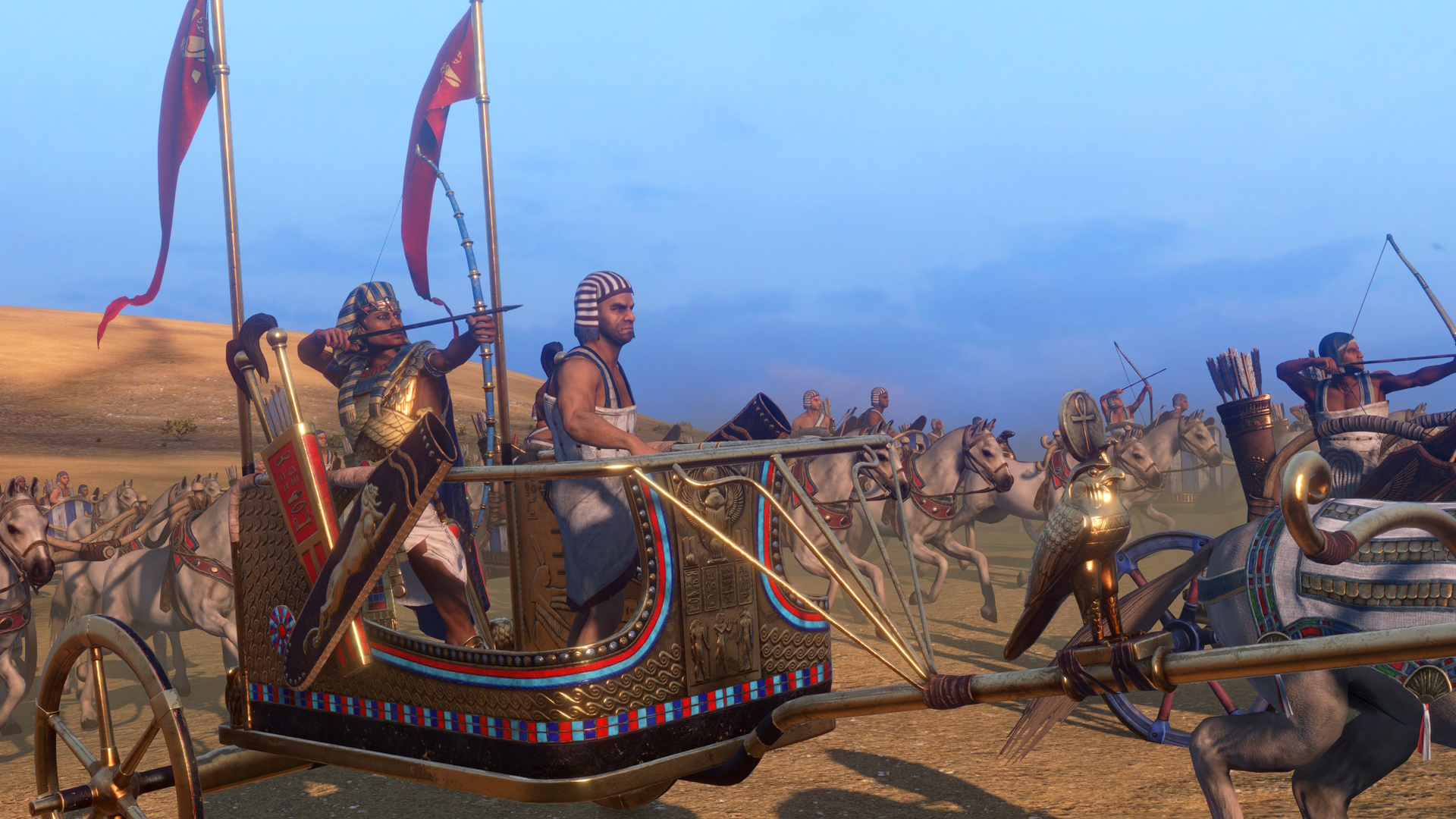 Der Screenshot von Total War: Pharaoh zeigt einen Fraktionsführer in einem Streitwagen, umgeben von verbündeten Streitkräften