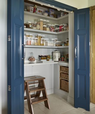 Walk-in pantry ideas with blue bi-fold doors and a step to reach high open shelving