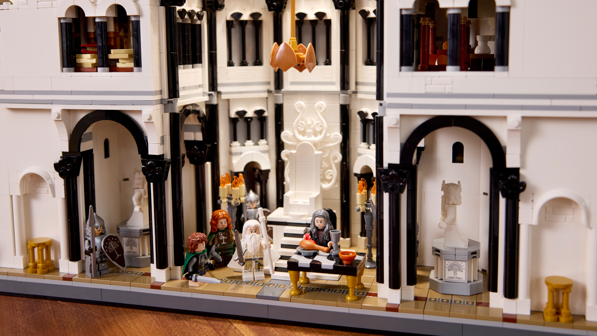 Lego Minas Tirith on a wooden surface, with multiple minifigures visible
