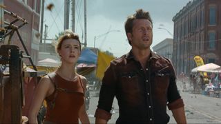 Daisy Edgar-Jones and Glen Powell stand in a desolated main street in a still from the movie "Twisters"