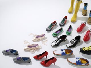 Lots of colourful shoes arranged in a path pattern on a white background