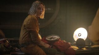 Rebecca Ferguson sits while working on a protective suit in Silo S2 E5 - 