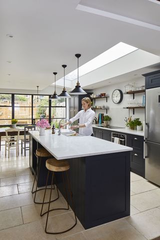 dak kitchen island in a bright white kitchen with pendant lights