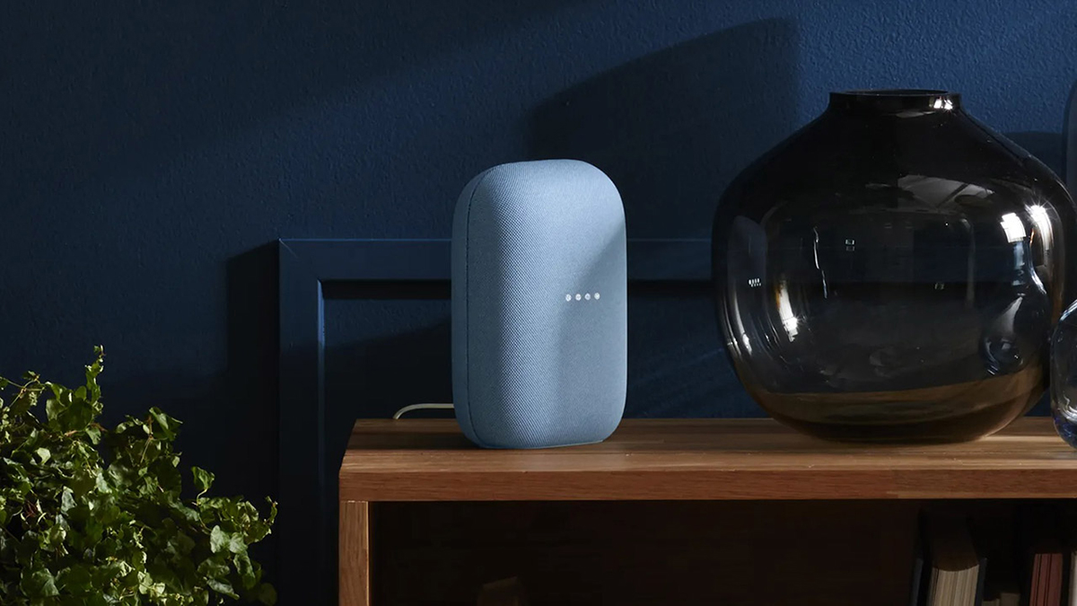 The Google Nest Audio smart speaker in grey on a wooden table