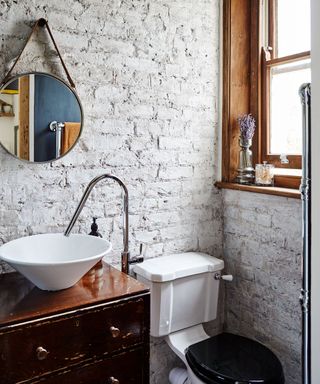 Exposed brickwork small bathroom with white floating sink