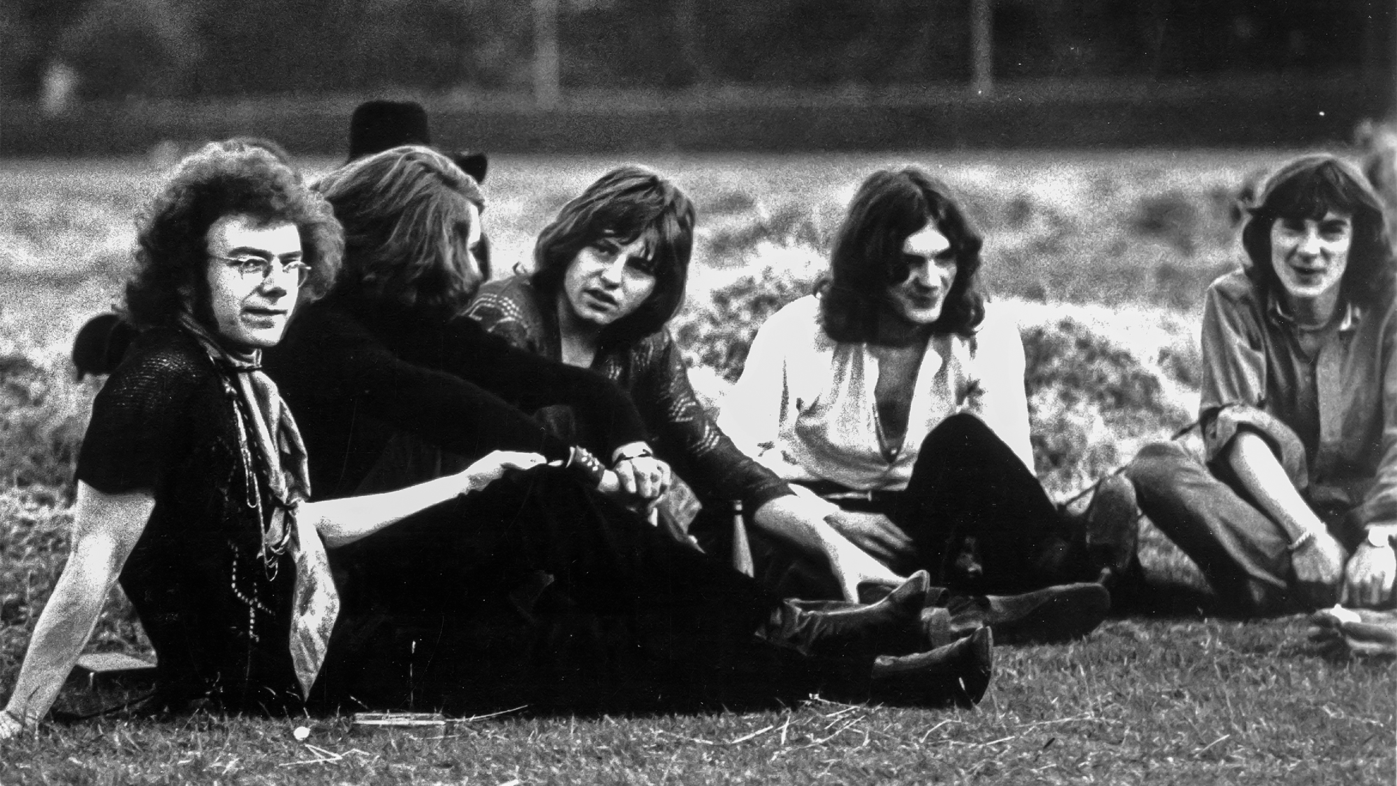 1969: The first lineup of the English rock band King Crimson pose for an Island Records publicity still sitting in a field in 1969. (L-R) Guitarist Robert Fripp, drummer Michael Giles, singer and guitarist Greg Lake, multi-instrumental Ian McDonald and lyricist Peter Sinfield