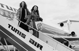 David Bailey portrait of two models on airplane steps