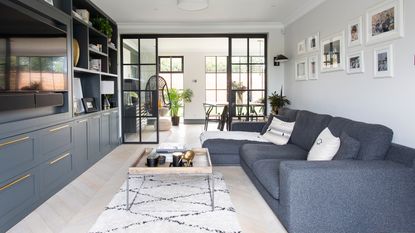 small white living room with corner sofa and shelving unit plus rug