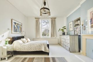 White bedroom with black headboard and chandelier