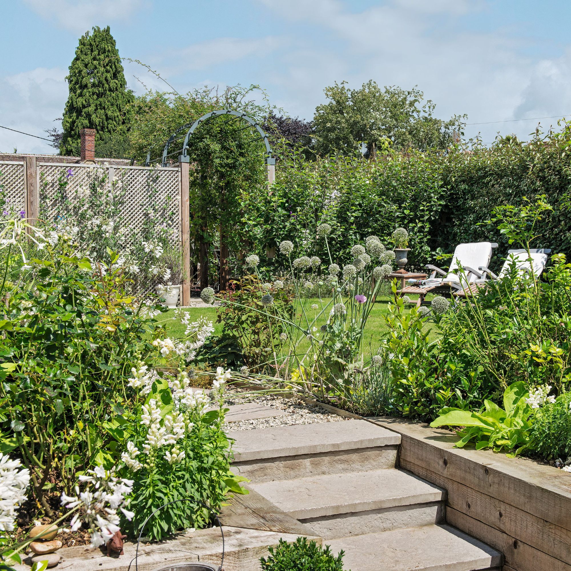 A terraced garden, transformed from a sloping garden, with patio, seating area and steps