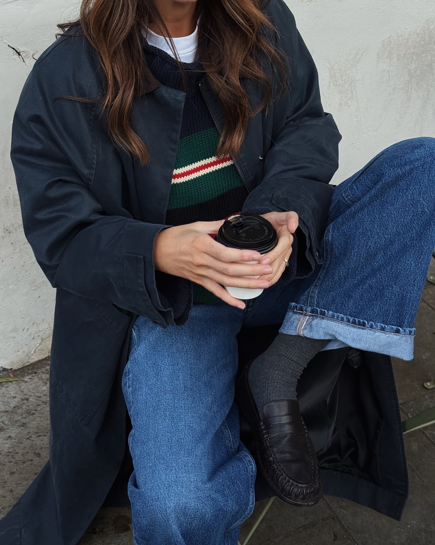 Kim Turkington wearing jeans, a trench coat and dark loafers.