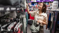 Woman in shop holding sports bra on a hanger