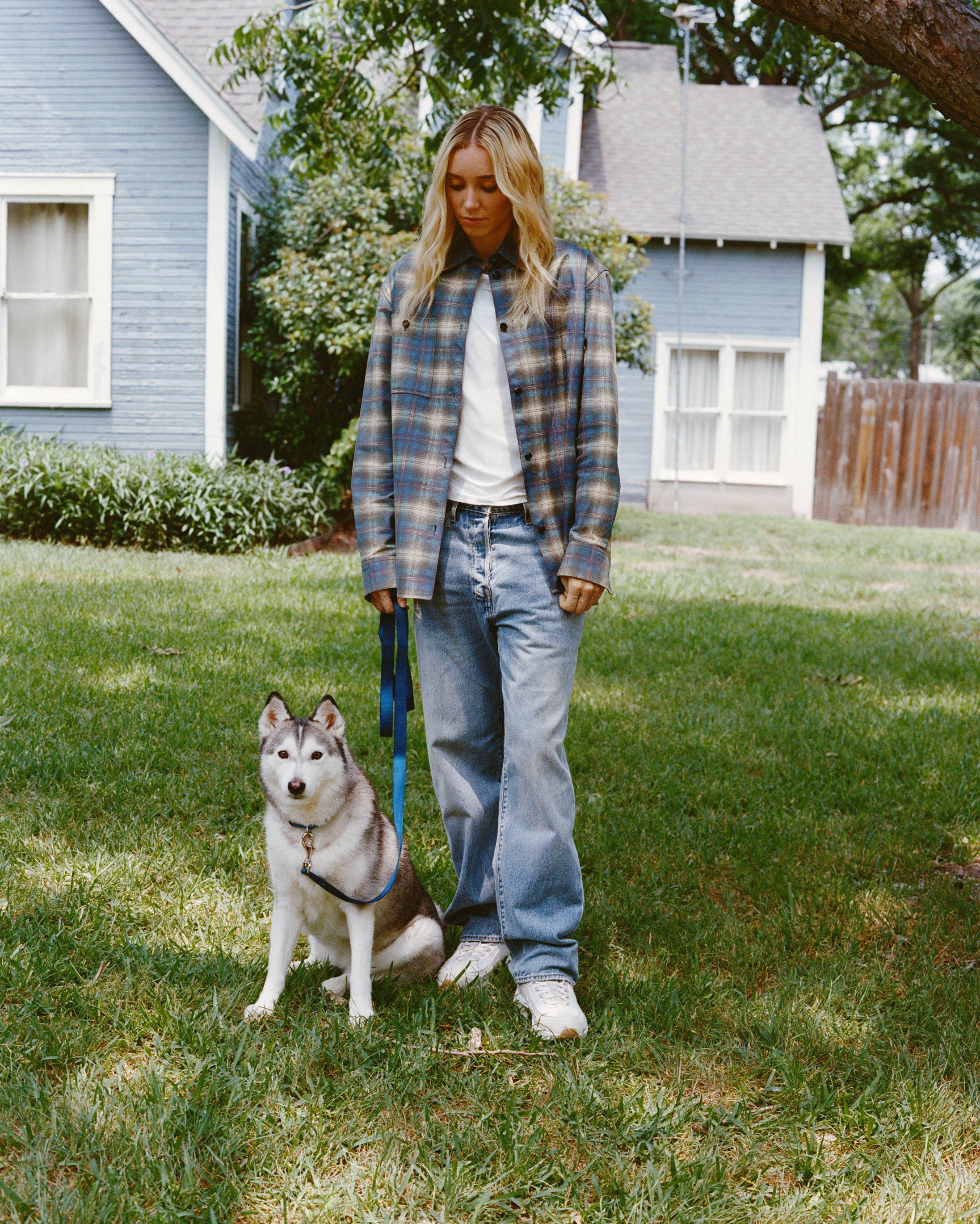 Paige Bueckers posing in new Nike x Levi's jeans with a husky.