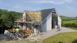 A house being newly renovated with scaffolding on the side constructing a new roof