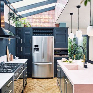 Open plan kitchen with dark blue cabinets and pink kitchen island