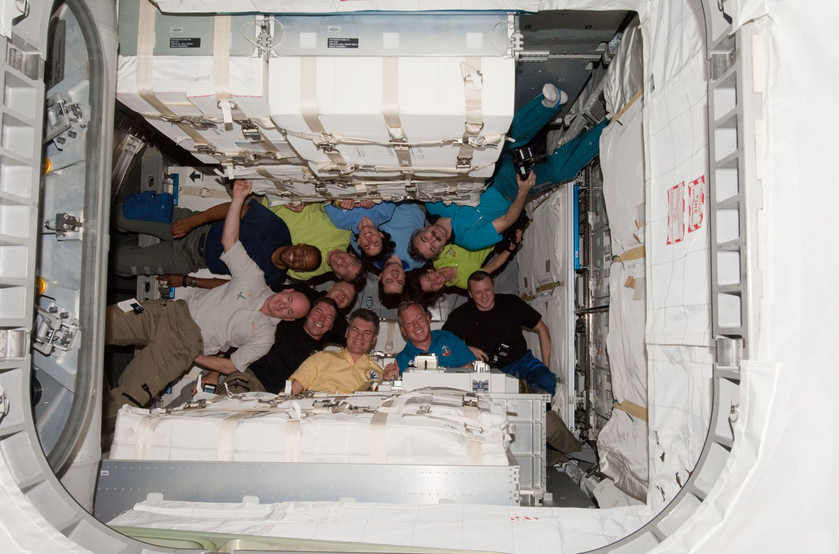 The crews of the International Space Station (Expedition 26) and the shuttle Discovery (STS-133) pose for a photo inside the newly attached Leonardo storage module, known as the Permanent Multipurpose Module, on March 1, 2011. 