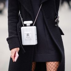 Woman wearing classic perfume bag Chanel No5 bottle handbag