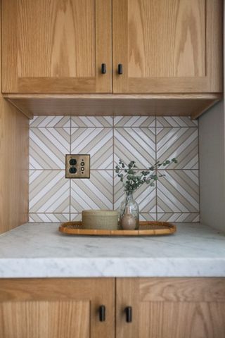 A kitchen with patterned and colored backsplash tiles