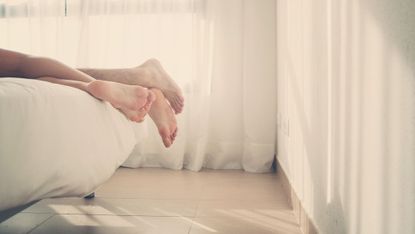 Feet of couple lying in bed