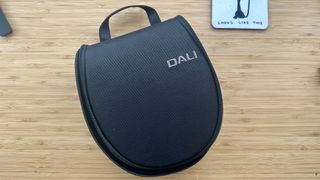 Dali IO-8 over-ear headphones carry case on a wood surface