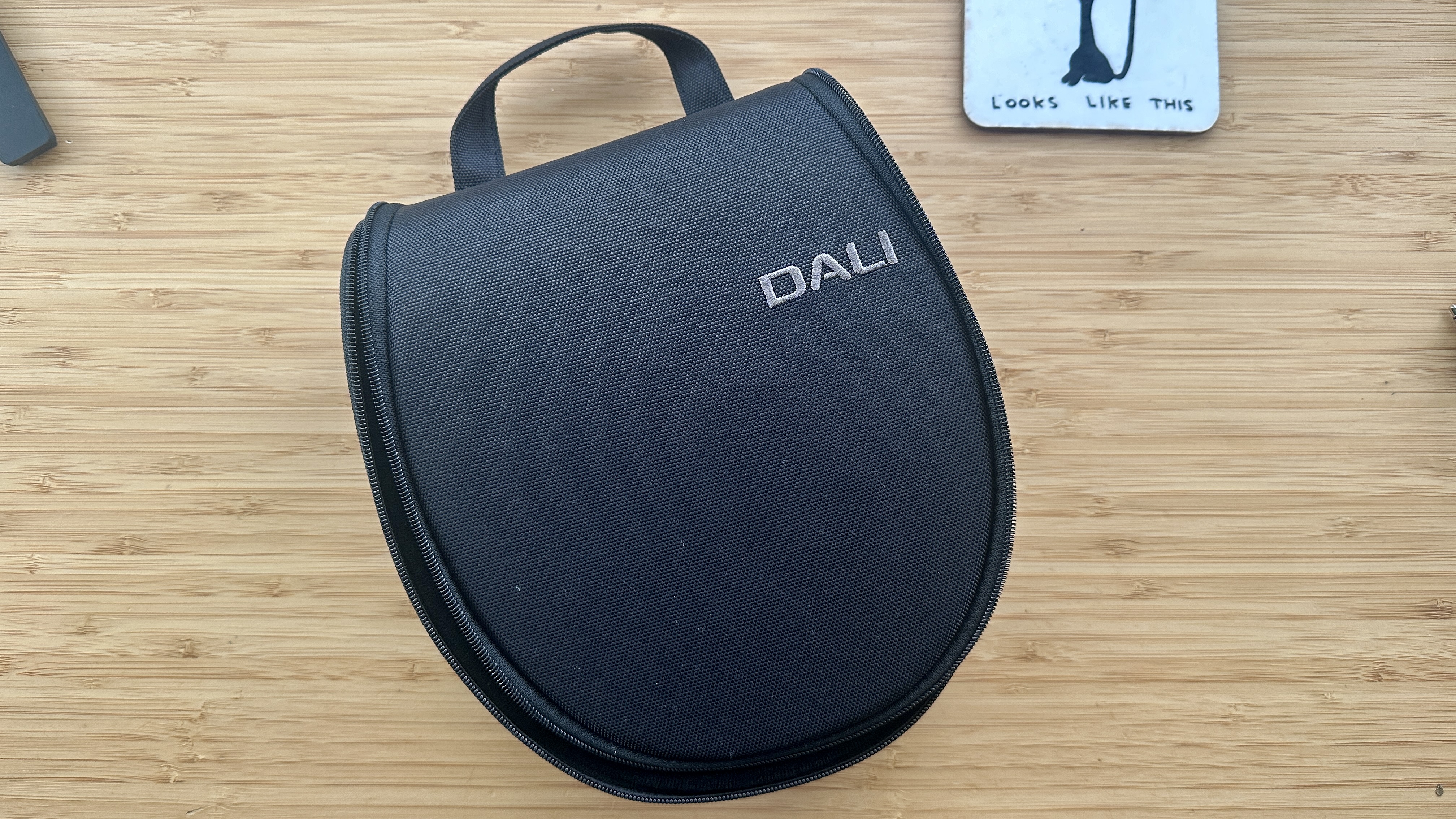 Dali IO-8 over-ear headphones carry case on a wood surface