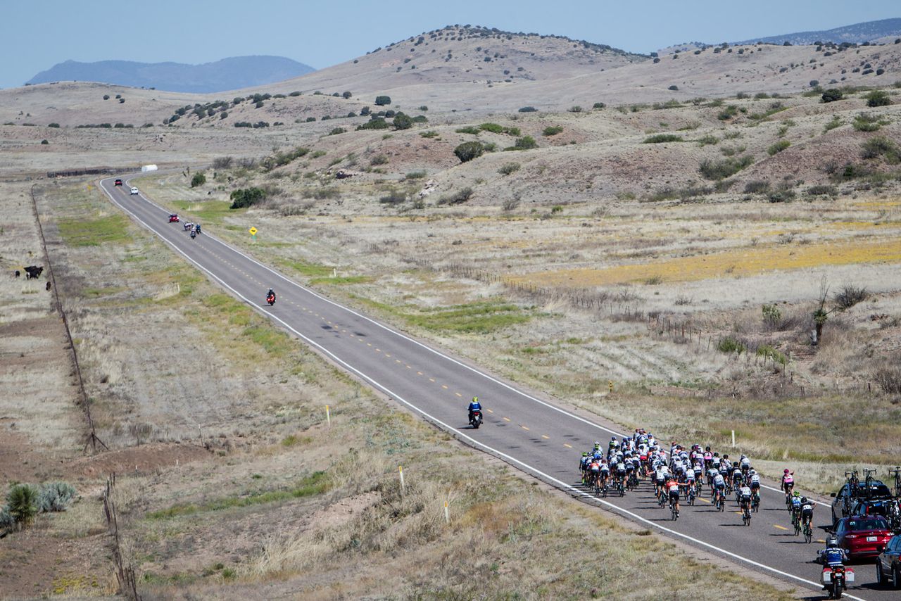 The women's peloton chases the break up the road