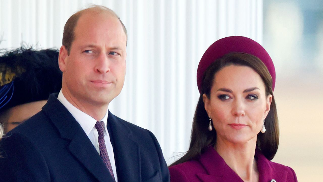 Prince William wears a suit and Kate Middleton wears a burgundy coat with matching hat