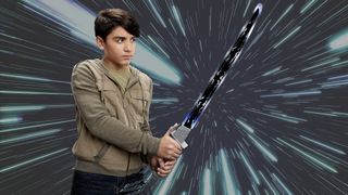 An image of a young person wielding a toy Mandalorian Darksaber against a starry background.