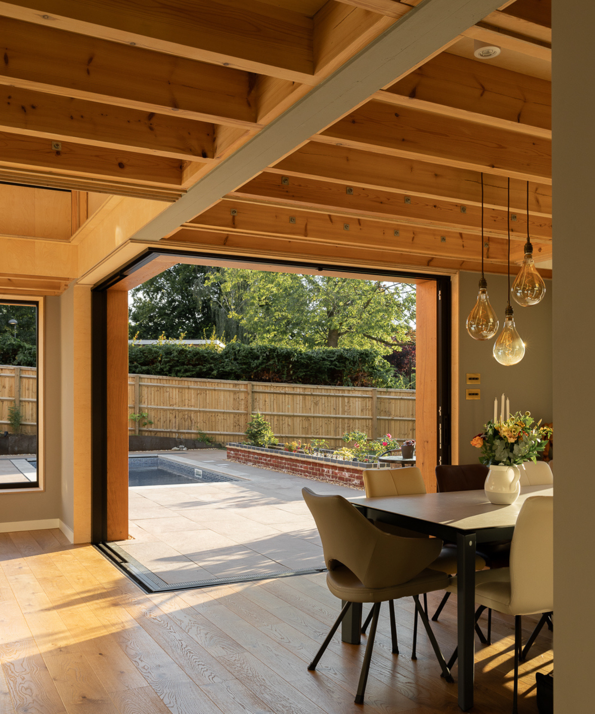 dining room with large doors and wooden beam ceiling